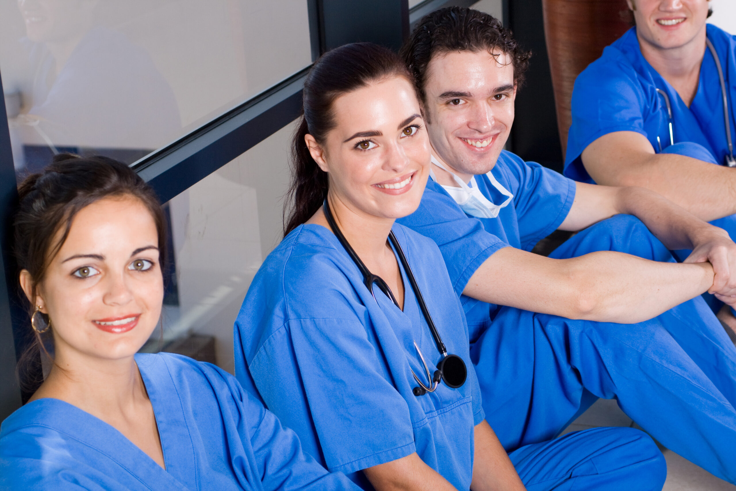 Group,Of,Young,Doctors,And,Nurses,Relaxing,In,Hospital,Hallway